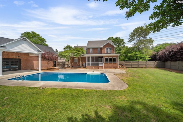 view of swimming pool featuring a sunroom, a fenced backyard, a lawn, and a fenced in pool