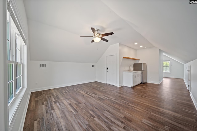 bonus room with dark wood-style flooring, ceiling fan, visible vents, and lofted ceiling