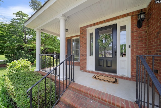 property entrance with covered porch and brick siding