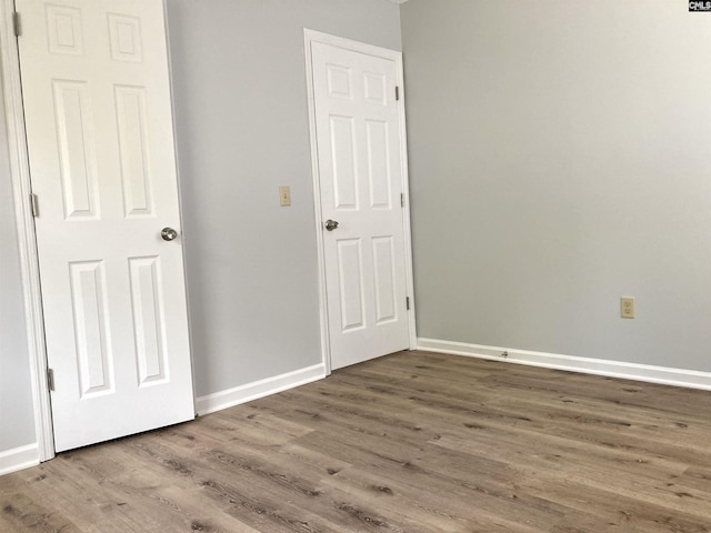 unfurnished bedroom with baseboards and wood finished floors