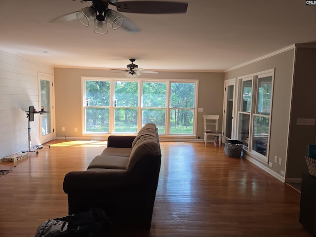 living room with crown molding, baseboards, ceiling fan, and wood finished floors