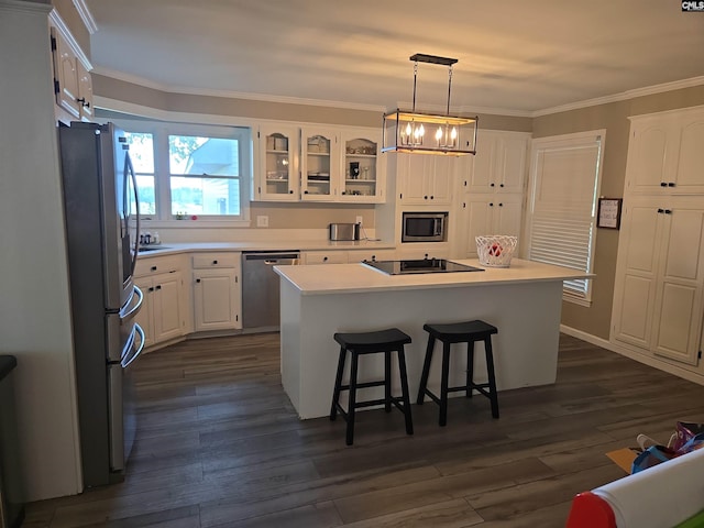 kitchen with a kitchen breakfast bar, glass insert cabinets, ornamental molding, stainless steel appliances, and white cabinetry