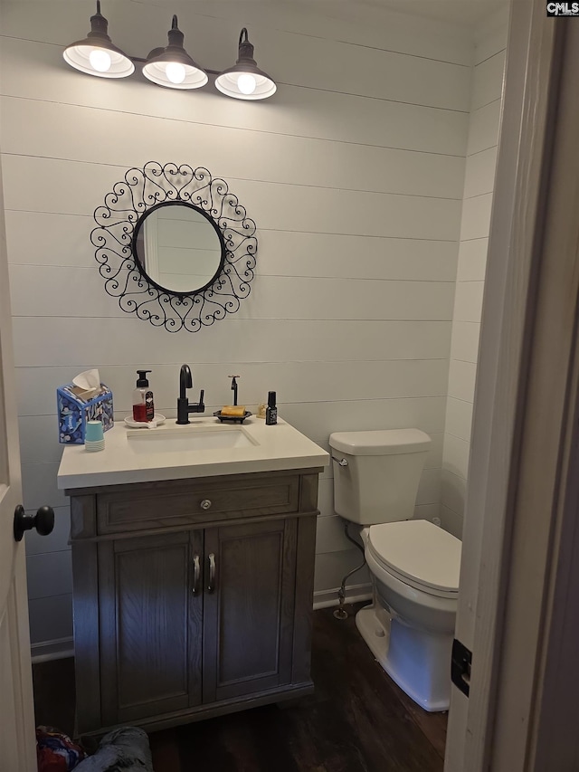 bathroom featuring vanity, toilet, and wood finished floors