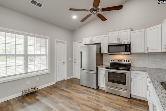 kitchen with visible vents, appliances with stainless steel finishes, a healthy amount of sunlight, and tasteful backsplash