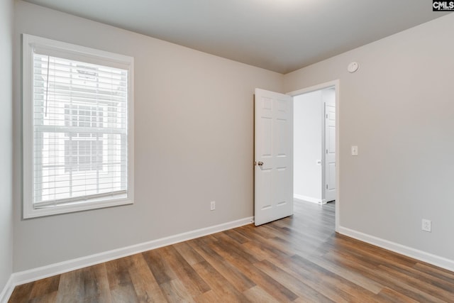 unfurnished room with baseboards and wood finished floors