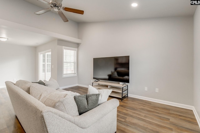 living room featuring wood finished floors, lofted ceiling, baseboards, ceiling fan, and recessed lighting