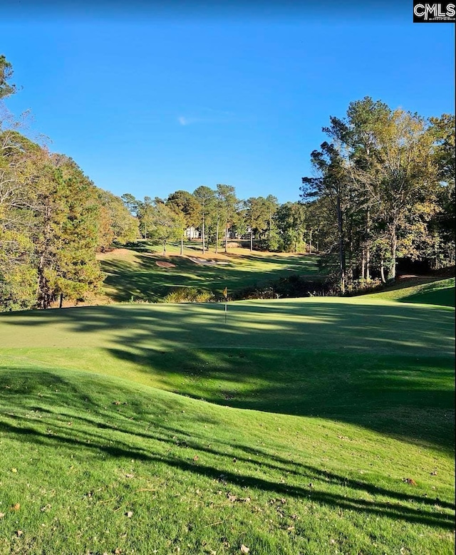 view of home's community featuring a lawn and golf course view