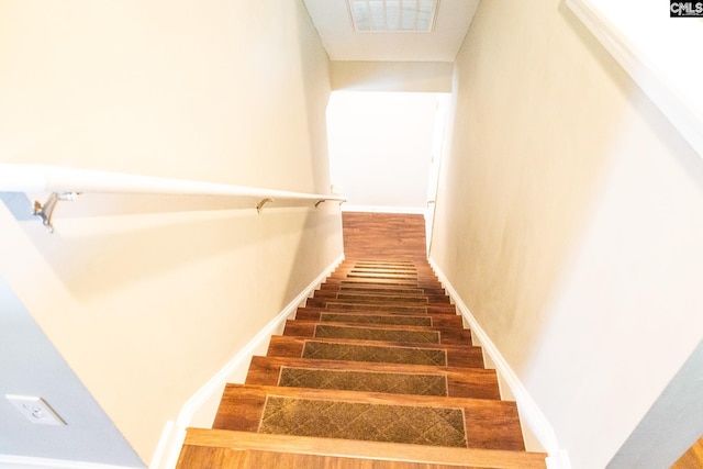 stairs featuring wood finished floors