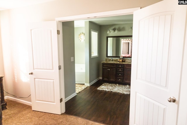bathroom featuring vanity, baseboards, and wood finished floors