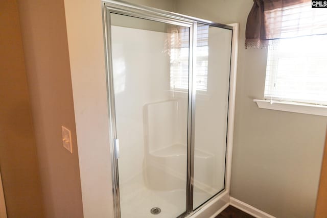 full bathroom with baseboards and a stall shower