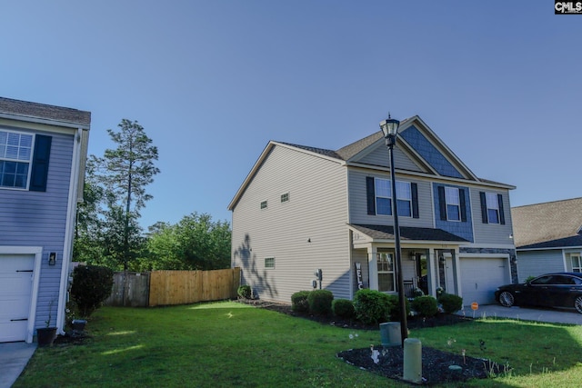 view of front of house featuring an attached garage, a front lawn, and fence
