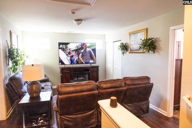 cinema room with baseboards and dark wood-style flooring