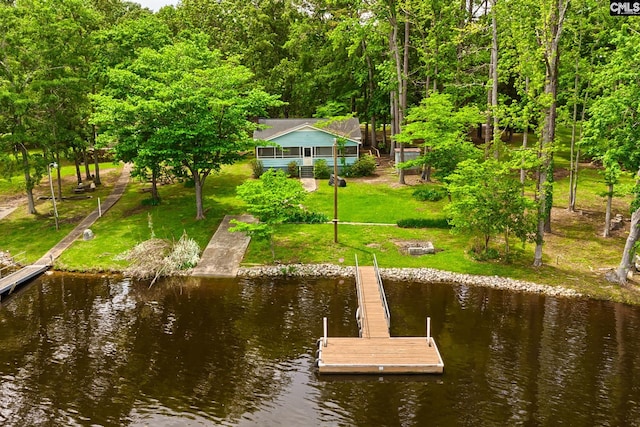 view of dock featuring a water view and a yard
