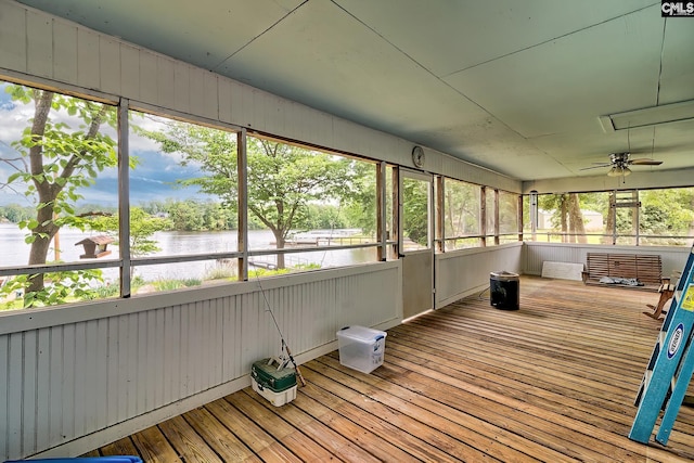 unfurnished sunroom featuring a ceiling fan and a water view
