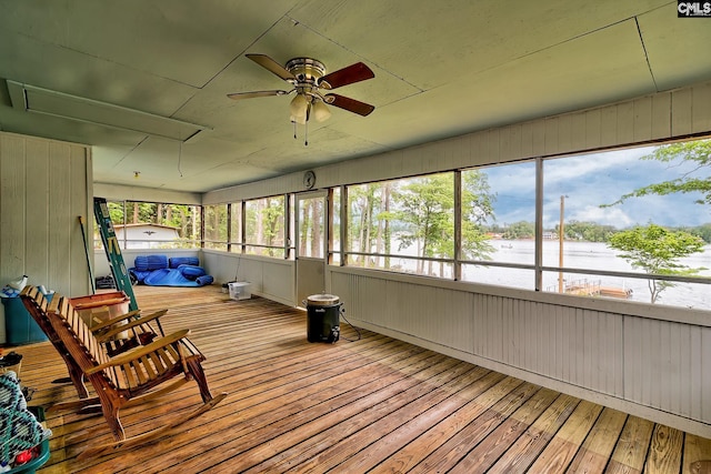 sunroom / solarium with plenty of natural light, a water view, and ceiling fan