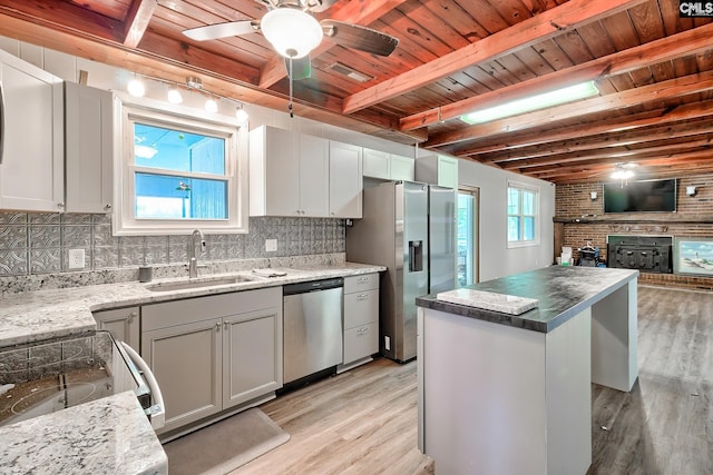 kitchen with wood ceiling, decorative backsplash, a sink, stainless steel appliances, and light wood-style flooring