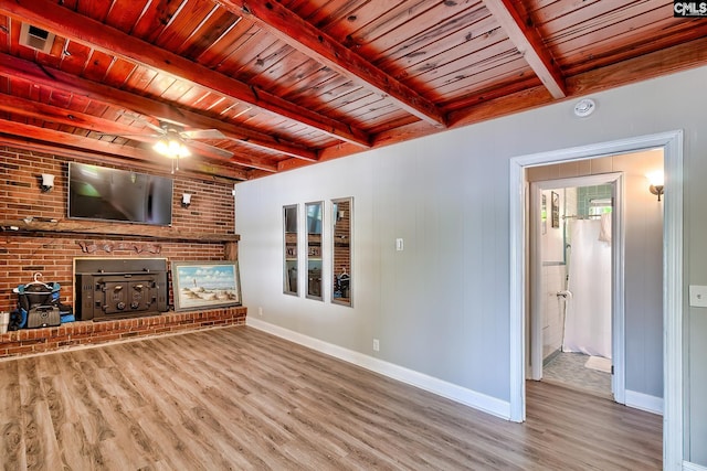 unfurnished living room with baseboards, beam ceiling, wooden ceiling, and wood finished floors