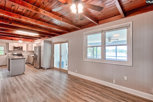 unfurnished living room with beamed ceiling, wooden ceiling, ceiling fan, and light wood-style flooring
