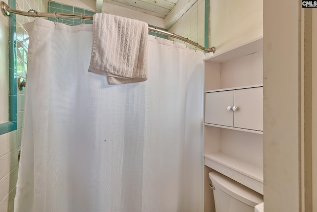 bathroom featuring toilet and a shower with shower curtain