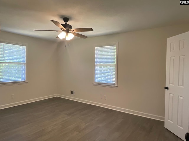 unfurnished room with dark wood-type flooring, baseboards, ceiling fan, and visible vents