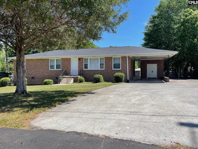 ranch-style house featuring an attached carport, concrete driveway, a front lawn, and brick siding