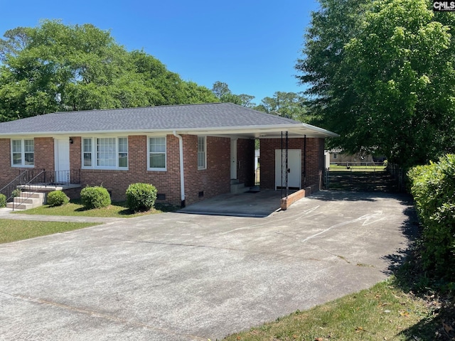 ranch-style home with roof with shingles, fence, brick siding, crawl space, and concrete driveway