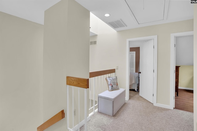 hall featuring carpet floors, attic access, baseboards, an upstairs landing, and visible vents