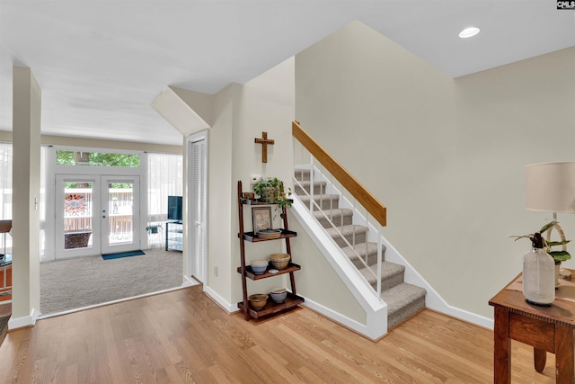 foyer entrance with stairs, wood finished floors, baseboards, recessed lighting, and french doors