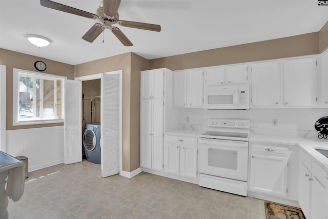 kitchen featuring ceiling fan, baseboards, white cabinets, washer / dryer, and white appliances