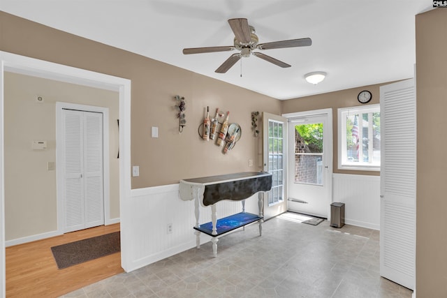 foyer with baseboards, wainscoting, and ceiling fan