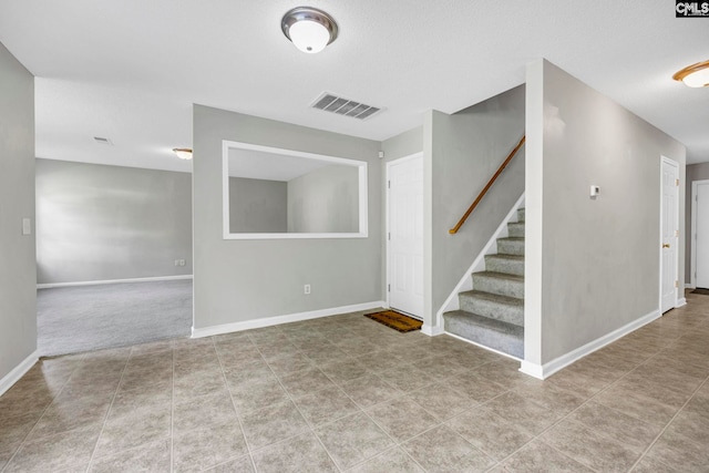 interior space featuring stairway, baseboards, and visible vents