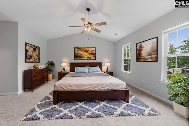 bedroom with light colored carpet, vaulted ceiling, multiple windows, and visible vents