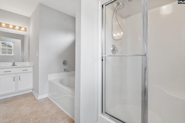 bathroom featuring a garden tub, tile patterned flooring, a shower stall, vanity, and baseboards
