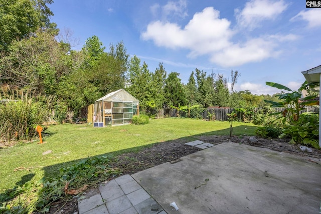 view of yard with a fenced backyard, an outdoor structure, an exterior structure, and a patio area