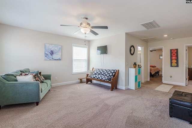 living room featuring carpet flooring, ceiling fan, visible vents, and baseboards