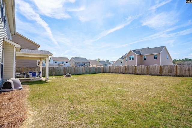 view of yard featuring a patio, a residential view, and a fenced backyard