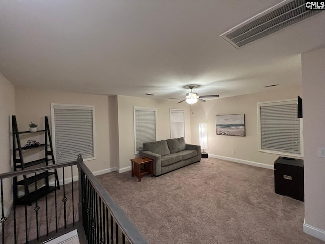 living area with baseboards, ceiling fan, carpet flooring, and visible vents
