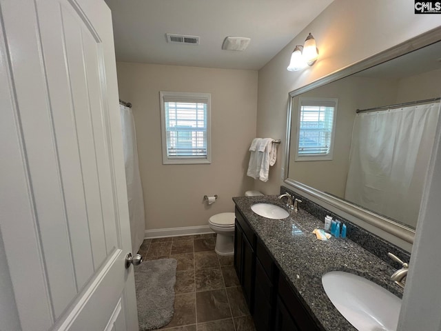 bathroom with a sink, baseboards, toilet, and visible vents