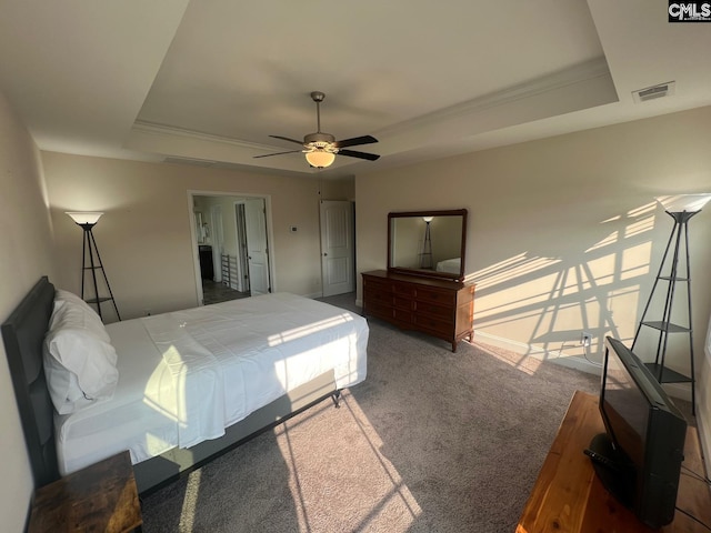 bedroom featuring ceiling fan, visible vents, crown molding, carpet floors, and a tray ceiling