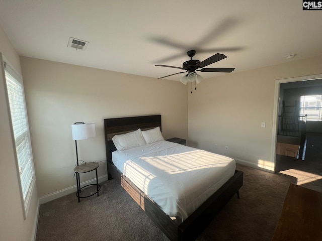carpeted bedroom with baseboards, a ceiling fan, and visible vents