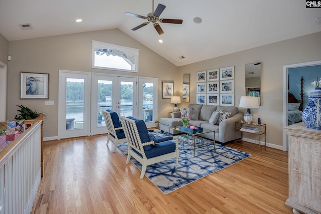 living room with visible vents, light wood-style floors, baseboards, high vaulted ceiling, and a ceiling fan