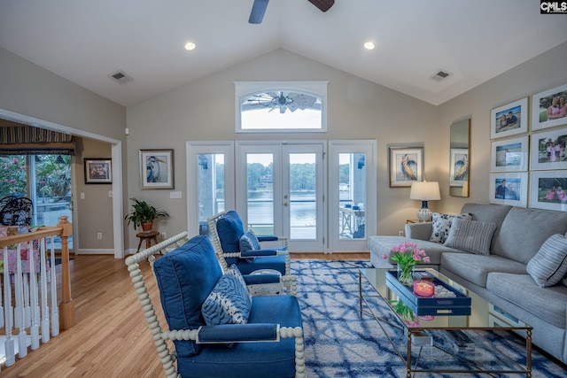 living area with a ceiling fan, high vaulted ceiling, visible vents, and french doors