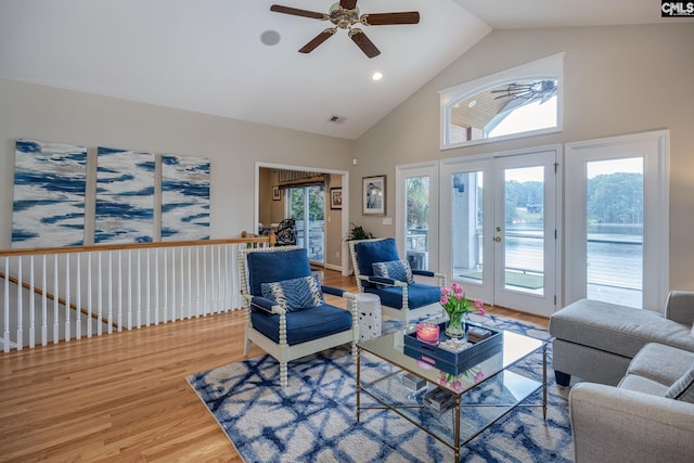 living area with ceiling fan, french doors, visible vents, wood finished floors, and high vaulted ceiling