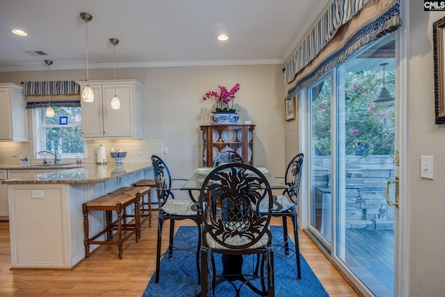 dining room with crown molding, recessed lighting, visible vents, and light wood-style floors