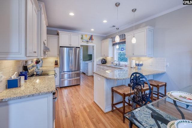 kitchen featuring freestanding refrigerator, white cabinetry, a peninsula, and light stone countertops