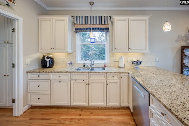 kitchen with stainless steel dishwasher, a sink, light wood finished floors, and decorative backsplash