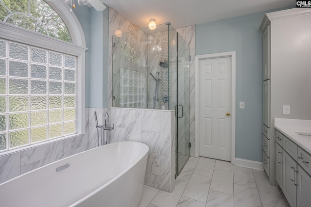 bathroom featuring vanity, a freestanding tub, marble finish floor, and a stall shower