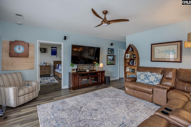 living room featuring baseboards, ceiling fan, visible vents, and wood finished floors