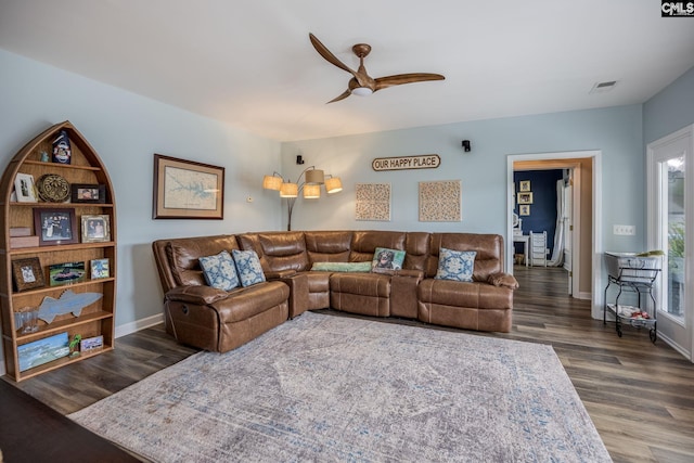 living room featuring baseboards, ceiling fan, visible vents, and wood finished floors