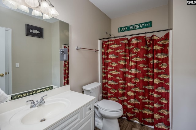 bathroom with a notable chandelier, vanity, toilet, curtained shower, and wood finished floors